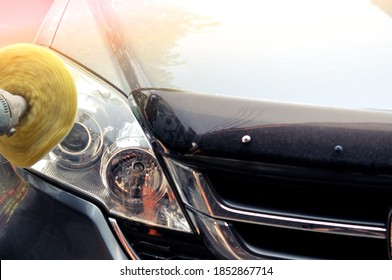 Big headlight cleaning on the car with power buffer machine at service station,Before and after cleaning car concept with a mechanic cleaning the headlights of a car using a power buffer machine 