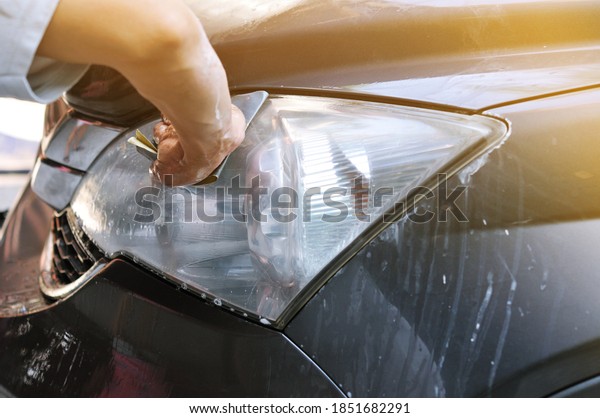 Big headlight cleaning on the car with power buffer\
machine at service station,Before and after cleaning car concept\
with a mechanic cleaning the headlights of a car using a power\
buffer machine 