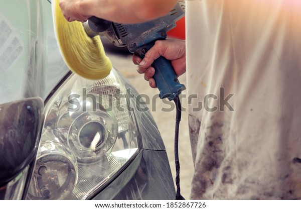 Big headlight cleaning on the car with power buffer\
machine at service station,Before and after cleaning car concept\
with a mechanic cleaning the headlights of a car using a power\
buffer machine 