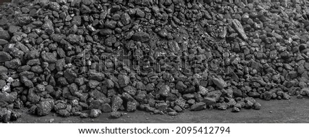 Big heap of dark black lump coal on floor bulk. Charcoal sorage at warehouse stock reserve. activated anthracite pile. Power and heat generation. Industrial and mining industry background
