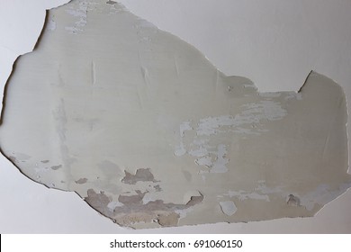A big hole in the plastered white ceiling