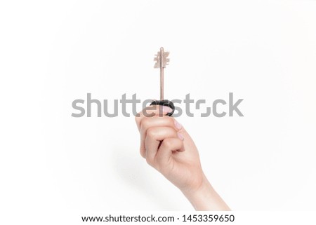 big house key in female hand, raised up, isolated on white background