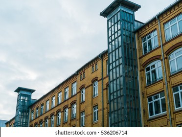 Big Industrial Building With Glass Elevator On The Outside