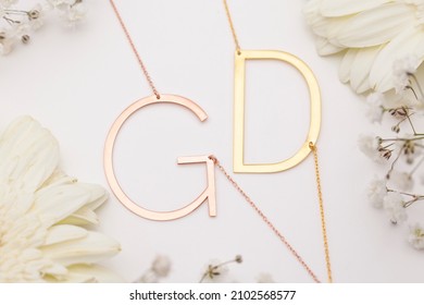 Big Initials Necklace On White Background Flowers Decorated . Silver Necklace Photo For Ecommerce.