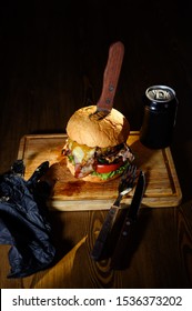 Big Juicy Burger With A Can Of Beer On A Cutting Board