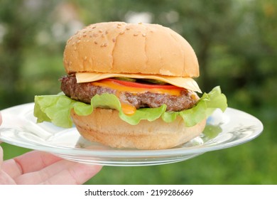 A Big Juicy Burger On A Plate In The Fresh Air