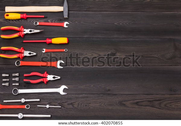 big kit of tools for car mechanic\
on brown brushed wooden table.  Close up photo and copy\
space