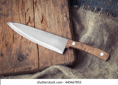 Big kitchen knife lying on an old cutting board