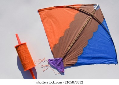 Big Kite and kite spool thread stringed to kite isolated on white background. Indian kite festival celebrated on Makar sankranti, uttarayan festival. Pongal Lohri poster backgrounds