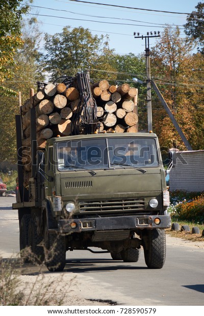 big lift truck full of wooden logs\
timber on road. concept of illegal felling of\
trees
