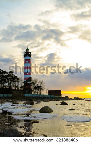 Big lighthouse on the beach at sunset