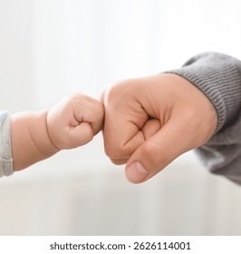 Conexión de hombres grandes y pequeños. Padre e hijo de bebé golpeando puños, en primer plano