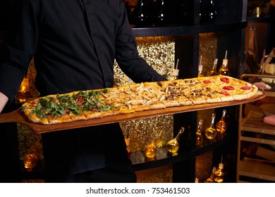 Big Long Mix Pizza With Cheese On Wooden Pizza Board, In Pizza Man Hands