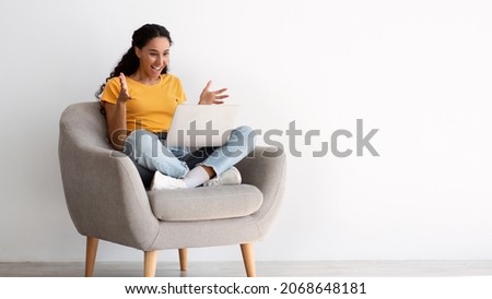Big Luck. Emotional Joyful Young Woman Sitting In Armchair With Laptop, Looking At Screen And Exclaiming With Excitement, Overjoyed Brunette Lady Won Online Lottery Or Amazed By Big Sales, Panorama