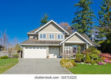Big luxury house with triple garage doors and nicely landscaped front yard. North America.