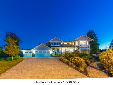 Big Luxury House With Two Garages And Long Nicely Paved Driveway At Dusk, Night Time In Suburbs Of Vancouver, Canada.