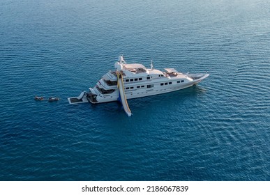 Big luxury white yacht anchoring in shallow water stands in the sea at sunset. Travel and vacation concept, marine entertainment
