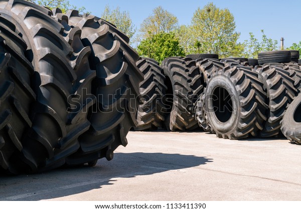 Big machines tires stack background. Industrial\
tires outside for sale