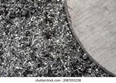 Big magnesium billet on shavings from miling machine. Macro shot. Top view industrial closeup photo. Photo of metal billet on swirly magnesium shavings. Industrial technological workwlow