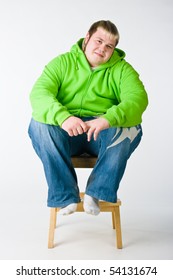 Big Man In A Green Jacket Sitting On A Chiar