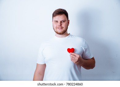 Big Man Holds Little Plush Heart On White Bakground