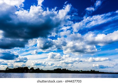 big massive clouds in the blue sky at a russian lake