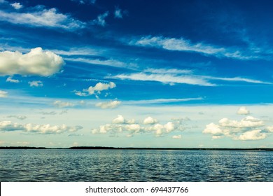 big massive clouds in the blue sky at a russian lake