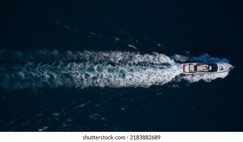 Big Mega Yacht Fast Movement On Dark Water In The Sea Top View. Large Super Yacht In Motion On Dark Water Aerial View.