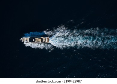 Big Mega Yacht Fast Movement On Dark Water In The Sea Top View. Large Super Yacht In Motion On Dark Water Aerial View.