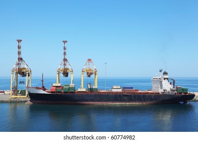big merchant ship with cargoes on a board at its moorings in port.