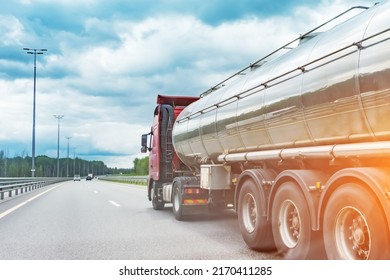 Big Metal Fuel Tanker Truck Shipping Fuel On The Countryside Road Against A Cloudy Sky