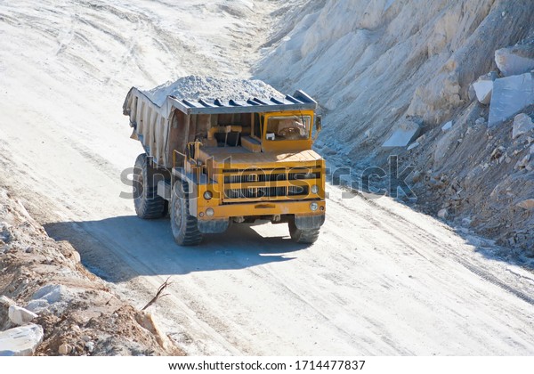 Big mining\
truck carries ore in a marble\
quarry