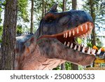 Big model of prehistoric dinosaur Tyrannosaurus rex in the nature. Realistic scenery.