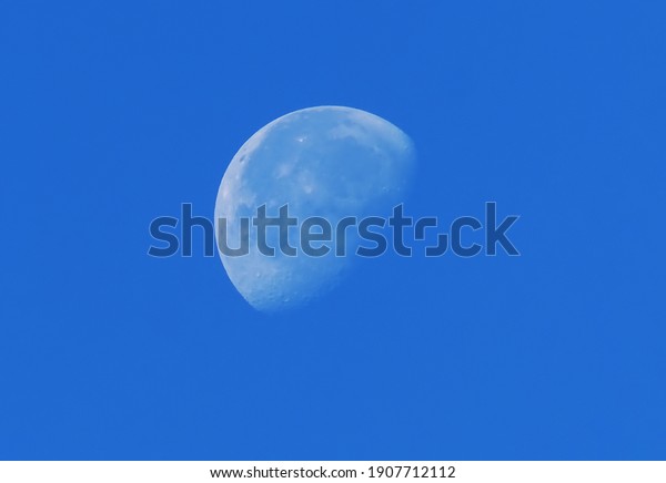 big moon against blue\
sky