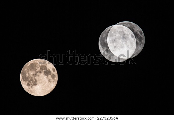 Big moon on dark night sky\
(multiple exposure showing the progression of the moon through the\
sky)