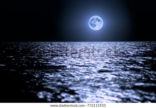 Big moon over the sea at\
night. moonlight on the waves, horizon. Long exposure. Beautiful\
landscape.