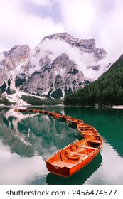 big mountain with clouds, Its side forest hill, a lake with many boats image.