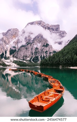 big mountain with clouds, Its side forest hill, a lake with many boats image.
