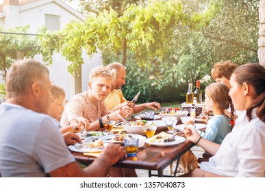 Big multigeneration family have dinner on open garden terrace - Powered by Shutterstock