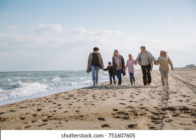 big multigenerational family walking together on beach at seaside - Shutterstock ID 751607605