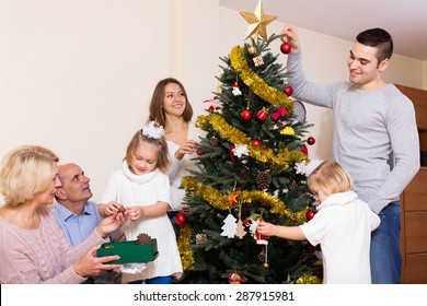 big multigenerational happy family with decorated Christmas tree