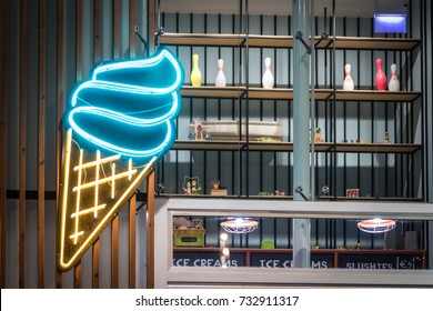 A big neon ice-cream sign on a cafe with toys seen in a window. - Powered by Shutterstock