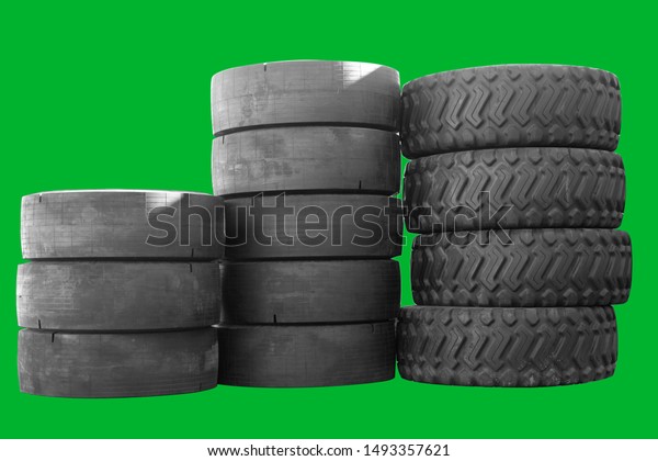 Big new tires for trucks. Car black tires are\
in a row. Isolated green\
background.