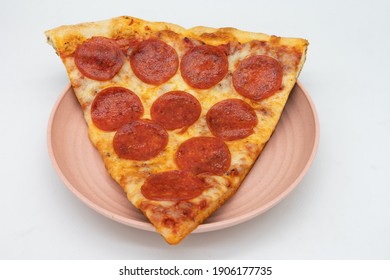 Big New York Style Slice Of Pepperoni Pizza On A Pink Plate