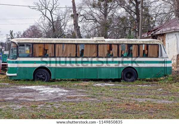 big old\
bus is standing on the street in the\
grass