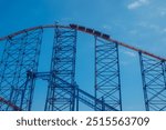 The Big One roller coaster at Blackpool Pleasure Beach stands as a colossal steel edifice against the backdrop of a vivid blue sky. The photo showcases the ride