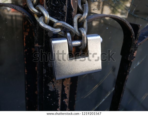 Big  Padlock in a Metal Gate with Big Chain for\
Security and Safe Guard