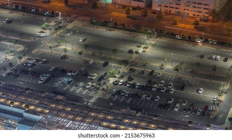 Big Parking Lot Near Mall Crowded By Many Cars Night Timelapse Aerial View. Vehicles Moves In And Out