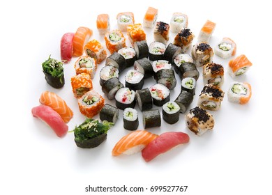 Big party sushi set isolated on white background. Japanese food delivery and take away. Fish and vegetable rolls, salmon and tuna nigiri and spicy gunkans with seaweed