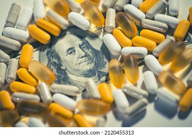 Big Pharma Conspiracy Theory. Medical Pills Lying On Top Of Hundred Of US Dollar Bill. Pharmacy And Healthcare Are Very Expensive